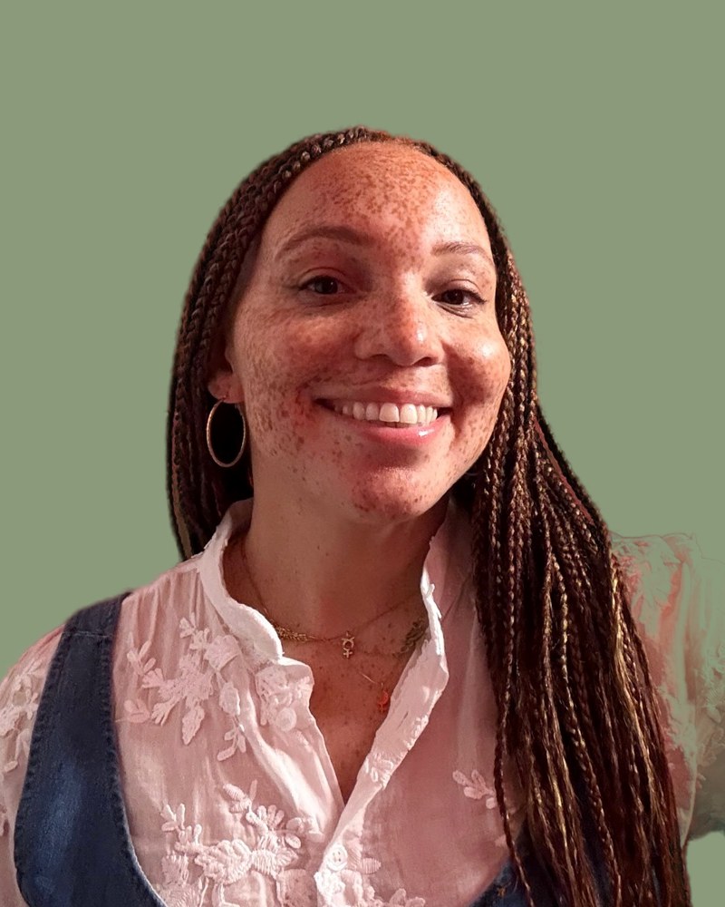 Ele Owens, smiling, in a white embroidered blouse